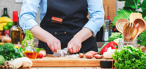 istock Cook cuts shallots onion with santoku knife in cozy kitchen with wooden table, kitchenware, vegetables, herbs and ingredients for cooking. Healthy vegan food, culinary, recipes, blogging 2206780027