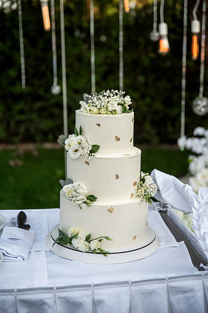 istock Three-tiered white wedding cake with fresh flowers 2206781319