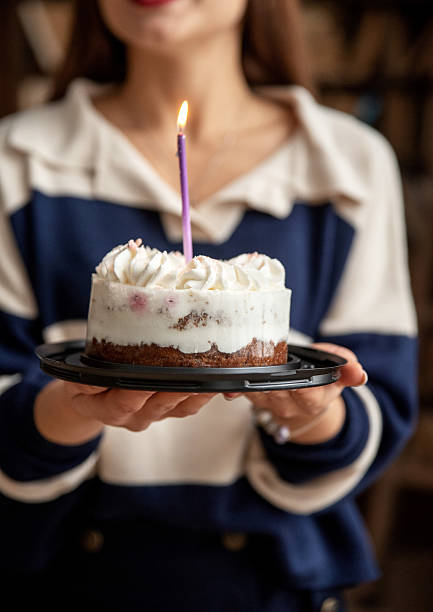 istock Girl holding a cake with a lit candle 2206781332