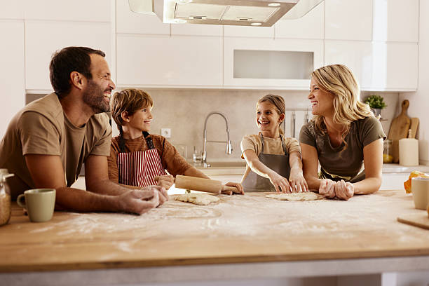 istock Happy family talking while making a cake in the kitchen. 2206786294
