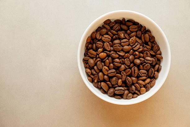 istock Freshly roasted coffee beans arranged in a white bowl on a light surface 2206787038