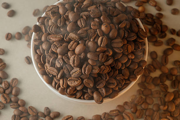 istock Rich brown coffee beans fill a white bowl with aromatic steam rising 2206787127