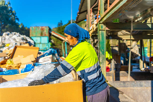 istock Worker separating materials outside a recycling plant 2206788131