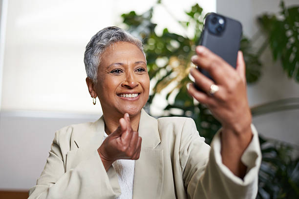 istock Senior Woman Engaged in a Video Call Using Her Smartphone in a Comfortable Indoor Setting 2206789735