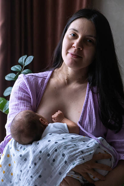 istock Mother Breastfeeding Baby by Window 2206790492