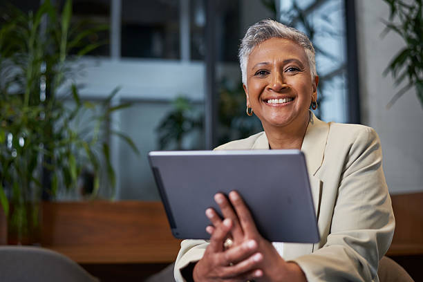 istock Confident Senior Woman Smiling While Using a Digital Tablet in a Modern Workplace Setup 2206790520