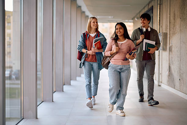 istock Group of happy university students walking through campus. 2206790632