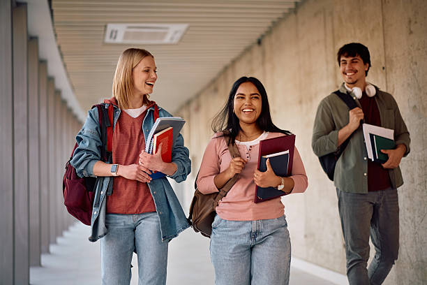 istock Happy students walking through the hallway while going on a lecture at the university 2206790651