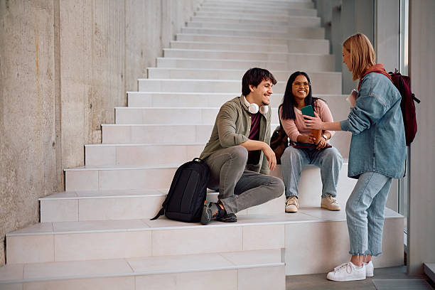 istock Multiracial group of happy college friends using cell phone in a hallway. 2206790785