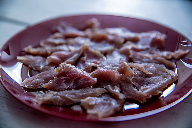 carpaccio preparing, slightly salted chunks of red meat on plate