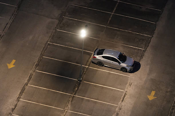 istock A silver car parked under a streetlight at night. 2206791657
