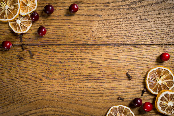istock Dried citrus slices and red berries arranged on rustic wooden surface for festive decoration or culinary presentation 2206793359