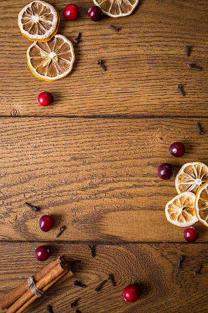istock Dried citrus slices, cranberries, and cinnamon sticks arranged on a rustic wooden table for a cozy autumn decoration 2206793790