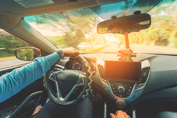 istock View of the driver hands driving on the highway. Driver hands on the steering wheel while driving on the asphalt 2206798269
