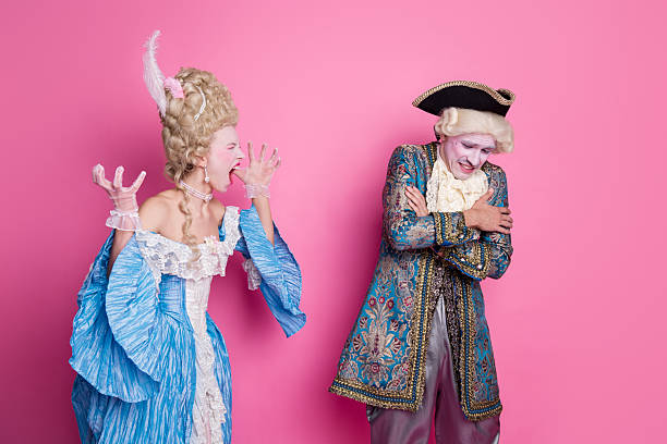 istock Two people dressed in elegant baroque costumes pose against a bright pink background, showcasing vintage fashion 2206798962