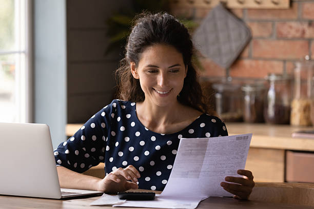 istock Smiling woman checking financial documents, calculating bills, using laptop 2206800610