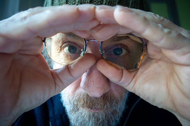 Senior man looking through finger glasses. People.