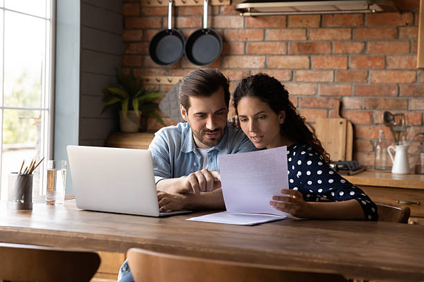 istock Young couple checking financial documents together, discussing loan agreement 2206804516