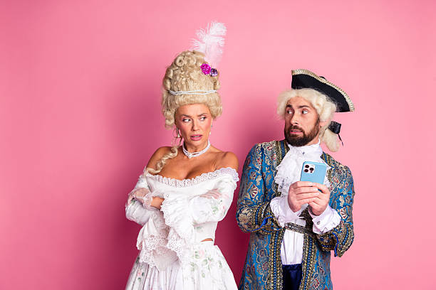istock Playful couple in modernized royal costumes posing against a pink background 2206804992