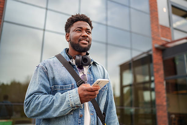istock Young Black Man Using Smartphone with a Positive Expression on the Street 2206805446