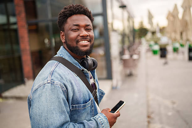 istock Young Black Man Using Smartphone with a Positive Expression on the Street 2206805447