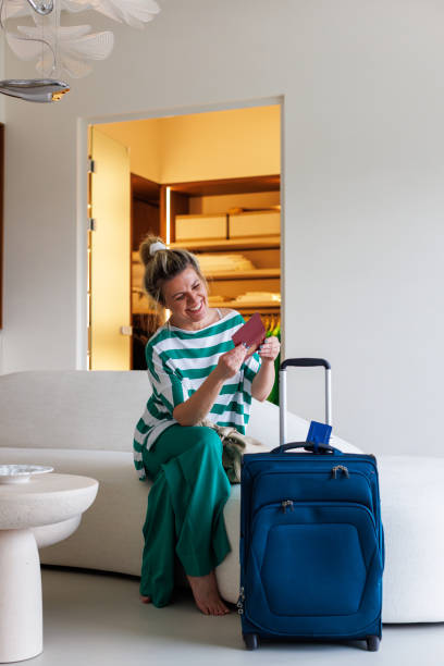 istock Woman packing suitcase on a bed in modern luxury home 2206806651