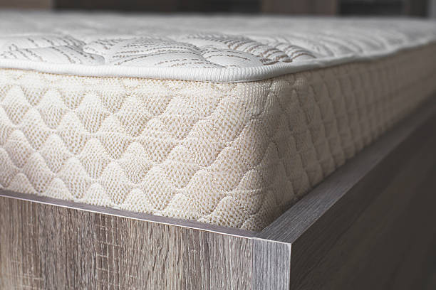 istock Comfortable orthopedic mattress with a quilted surface on a wooden bed frame, showcasing high-quality fabric texture and ergonomic design for restful sleep 2206808142