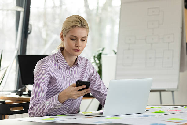 istock Focused female employee work on laptop use smartphone 2206809385