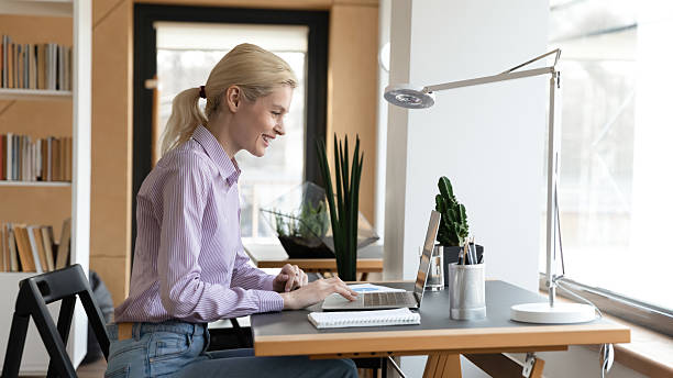 istock Smiling woman work online on laptop in office 2206810285