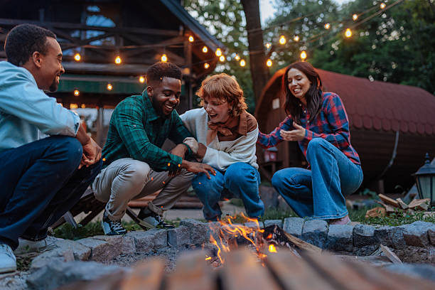 istock Friends laughing and warming up around bonfire in backyard 2206812910