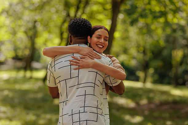 istock Interracial couple hugging in the park, showing love and affection 2206813073