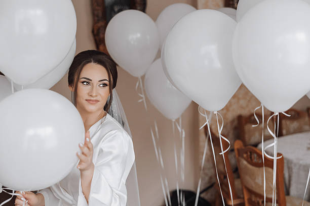 istock A bride is holding a bunch of white balloons 2206813725