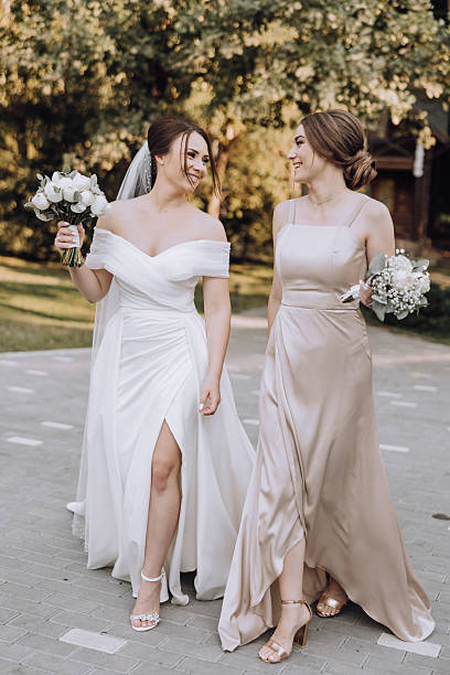 istock Two women in wedding dresses walk down a sidewalk 2206814032