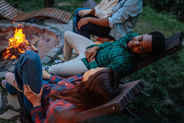 Friends relaxing around bonfire in the evening