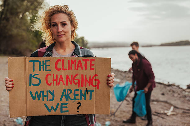 istock Woman holding protest sign about climate change by the river 2206815516