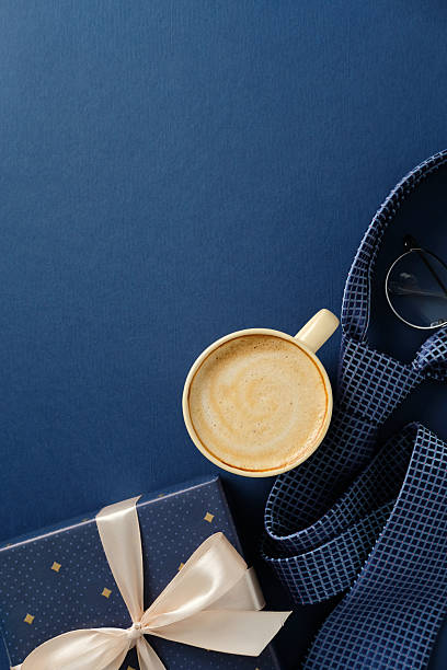 istock Happy Father's day concept. Elegant flat lay composition with coffee cup, gift box, and necktie on navy blue background 2206815643