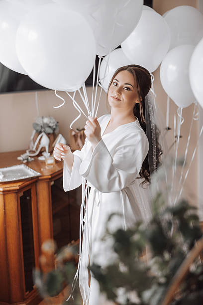istock A bride is holding a bunch of white balloons in her hand 2206818955