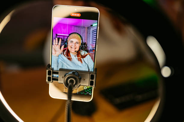 istock Young Woman Streaming On A Phone While Playing A Video Game On Her Desktop PC 2206820886