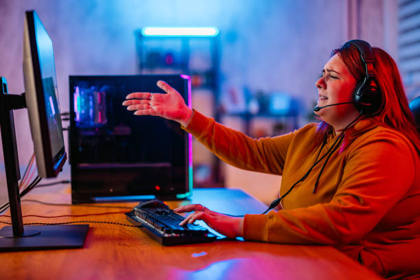 istock Young Woman Losing While Playing A Video Game On Her Desktop PC 2206821758