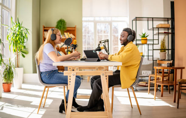 istock Engaging conversation between young adults in a vibrant podcast studio with advanced audio equipment and cheerful atmosphere 2206823197