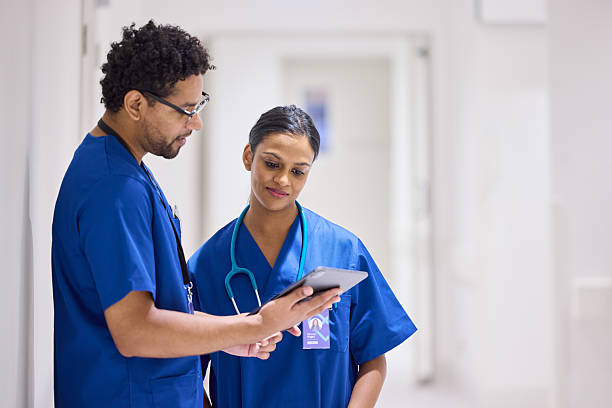 istock Male nurse discussing with colleague through tablet PC 2206823757