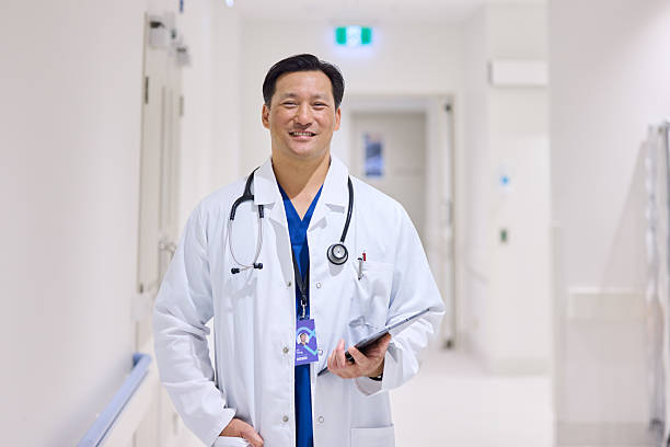 istock Smiling doctor with digital tablet wearing lab coat 2206823790