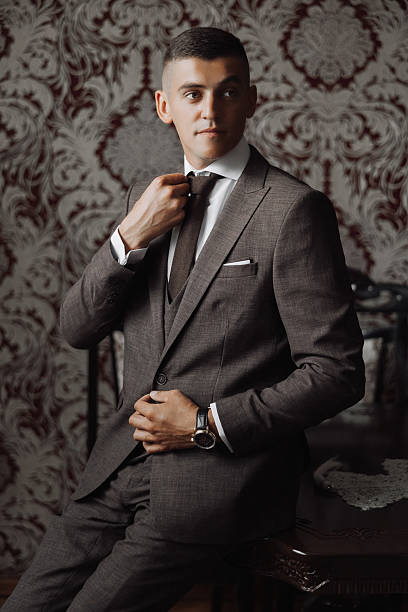 istock A man in a suit is sitting at a table and adjusting his tie 2206824566