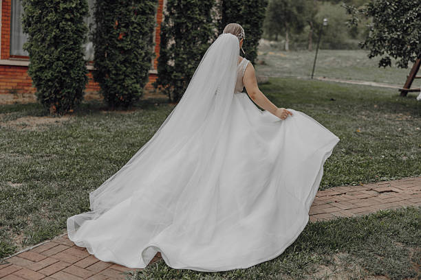 istock A woman in a white dress is walking down a brick path 2206824650