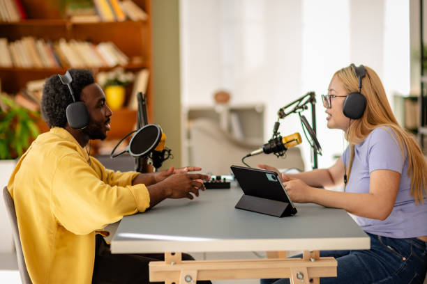 istock Engaging discussion between two young adults in a podcast studio during a live recording session 2206824664