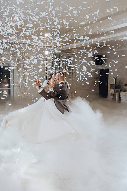 istock A bride and groom are dancing in the air with confetti falling around them 2206824691