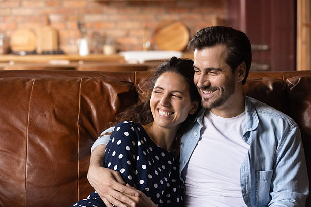 istock Close up dreamy smiling young couple hugging, sitting on couch 2206825111