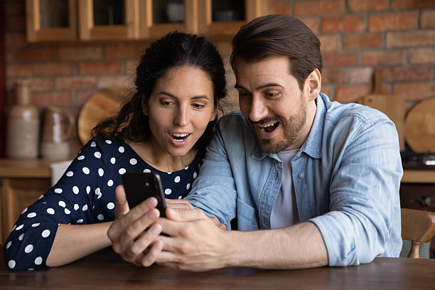 istock Close up overjoyed couple using phone, reading unexpected good news 2206828097