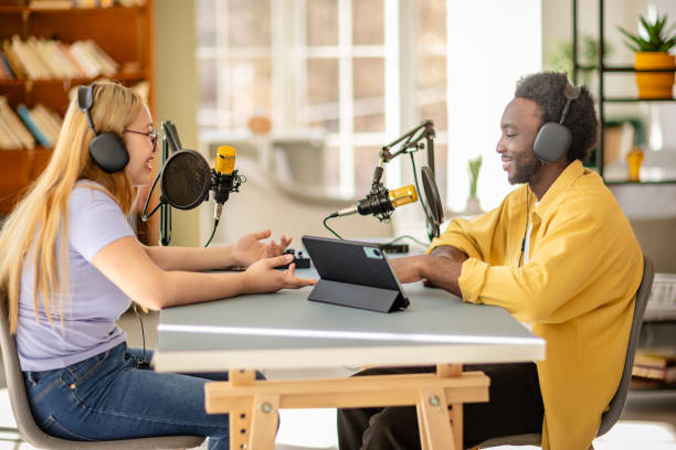 istock Engaging podcast discussion between two young adults in a modern studio setting focused on journalism and communication 2206828194