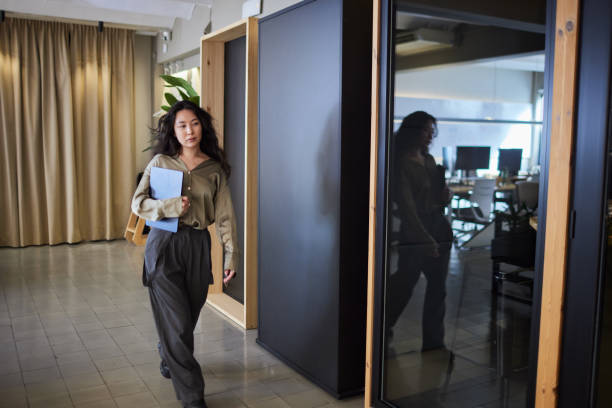 istock Millennial office worker walking with a laptop under their arm. 2206828824